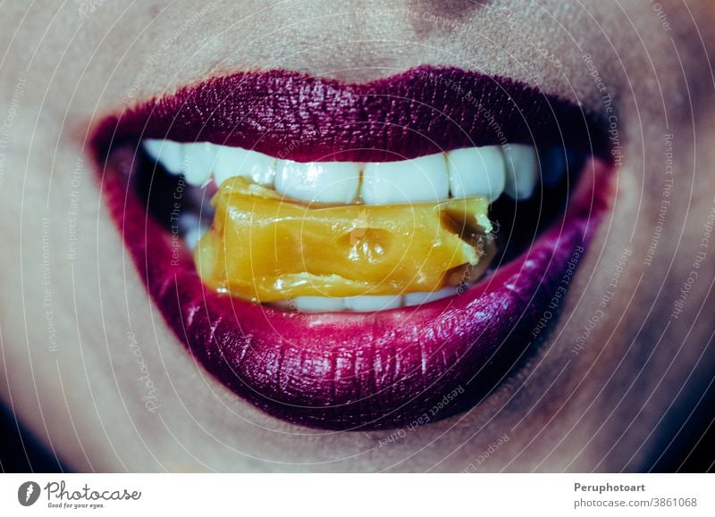 Close-up of woman mouth biting caramel candy closeup female food lips red girl person tasty teeth young bite sexy pink caucasian eating face makeup sugar