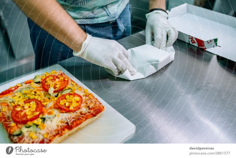 Unrecognizable cook packing takeaway orders unrecognizable preparing orders gloves hygiene safe food vegetable pizza industrial kitchen package take away