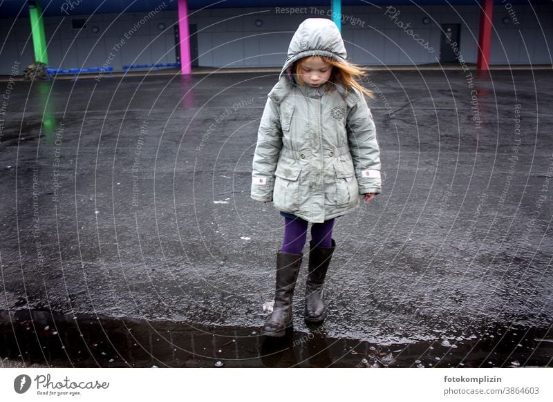 Child stands alone in a schoolyard Schoolchild Girl Schoolyard concentrated Empty Loneliness Infancy Dreamily waiting sad Lonely Earnest Hesitate children