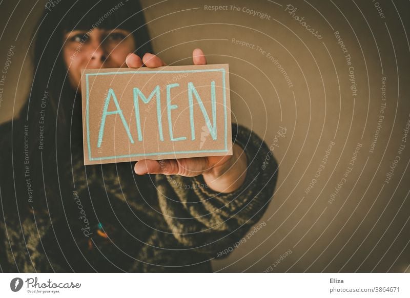 Young woman holding a sign saying Amen amen Church Heart Prayer pray Religion and faith religion Christianity Judaism praying Love Belief believe Holy
