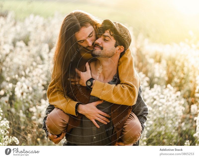 Affectionate gay couple cuddling in field homosexual men love hug romantic relationship lgbt young happy ethnic male together affection embrace tender boyfriend