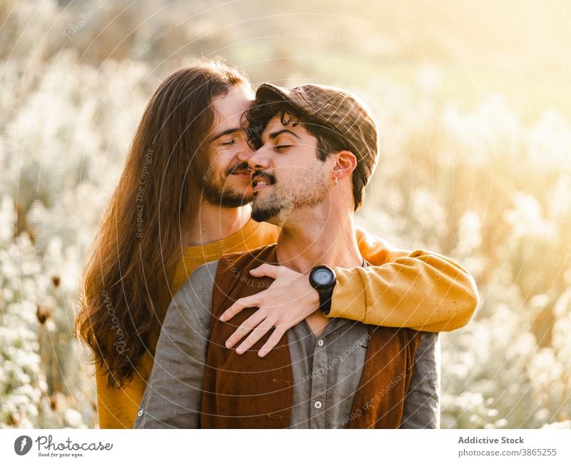 Happy gay couple hugging in nature homosexual men love embrace passion intimate romantic relationship lgbt young happy ethnic male together affection tender