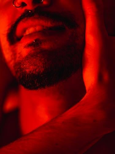 Gay couple during intimate moment in red light homosexual gay love passion romantic bed relationship lgbt ethnic male together affection tender boyfriend beard