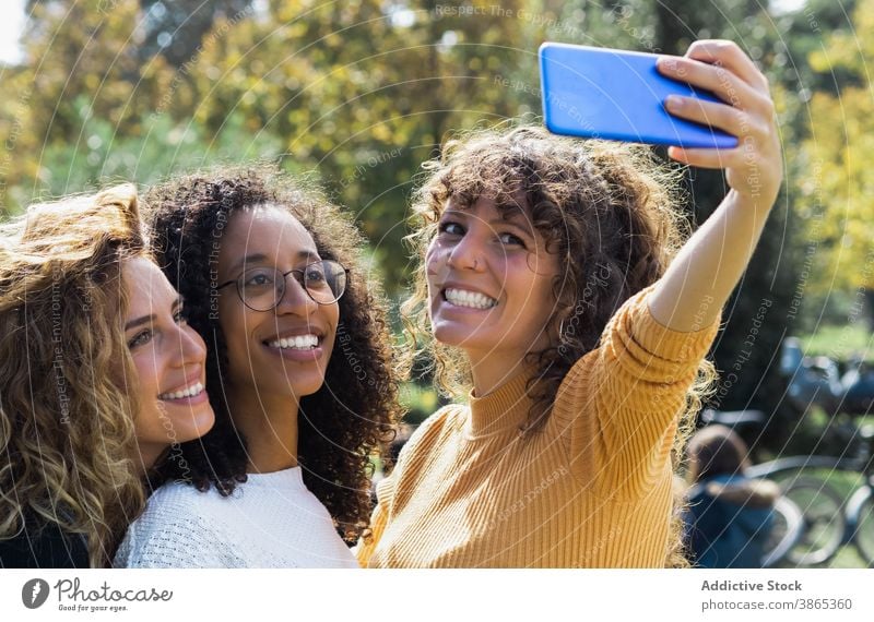 Cheerful multiethnic friends taking selfie in park women together friendship cheerful having fun friendly smartphone multiracial diverse african american black