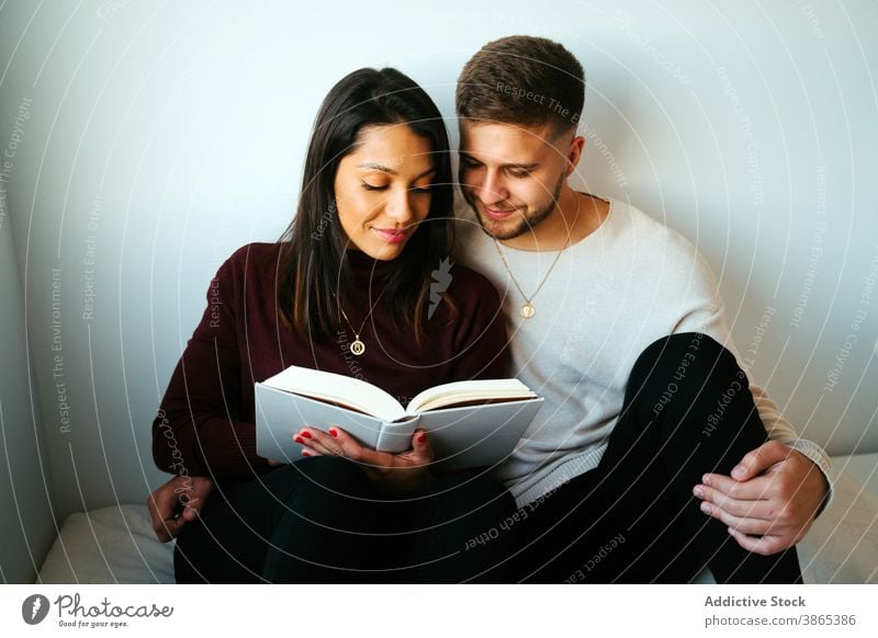 Calm couple reading book on bed together relax literature cuddle bedroom weekend interesting cozy relationship love peaceful romantic sit novel girlfriend