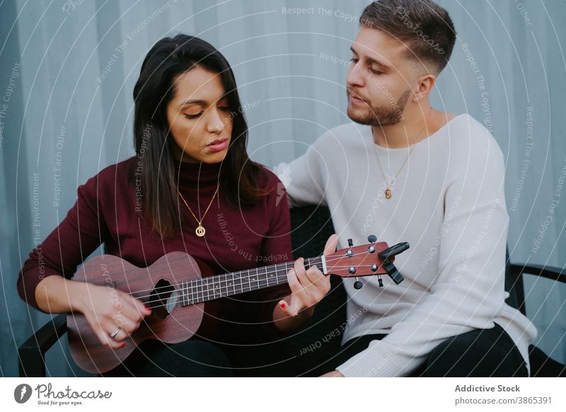 Couple playing ukulele on terrace of compact house couple backyard event relax container music together tranquil relationship song love melody evening dwell