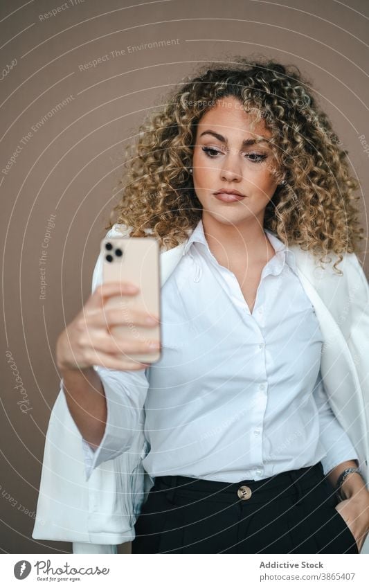 Charming woman taking selfie on smartphone smiling happy self portrait make face lip studio charming female style contemporary trendy gadget device mobile