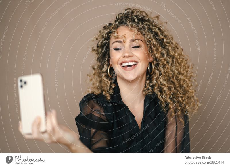 Charming woman taking selfie on smartphone smiling happy self portrait make face lip studio charming female style contemporary trendy gadget device mobile