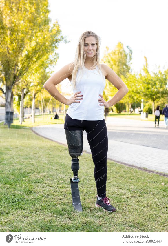 Cheerful sportswoman with artificial limb of leg preparing for training paralympic runner prosthesis bionic female workout athlete city prepare ponytail slim