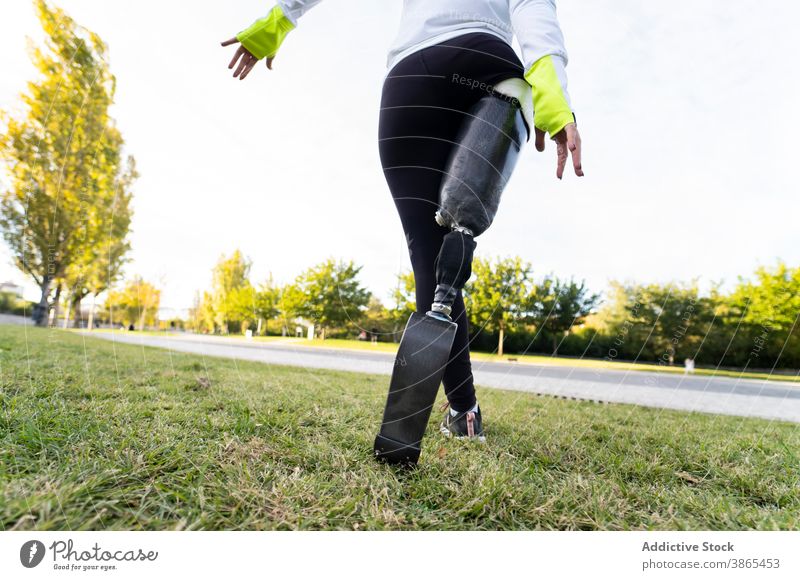 Crop runner with leg prosthesis training in park paralympic woman sportswoman artificial limb exercise female bionic workout practice energy professional active
