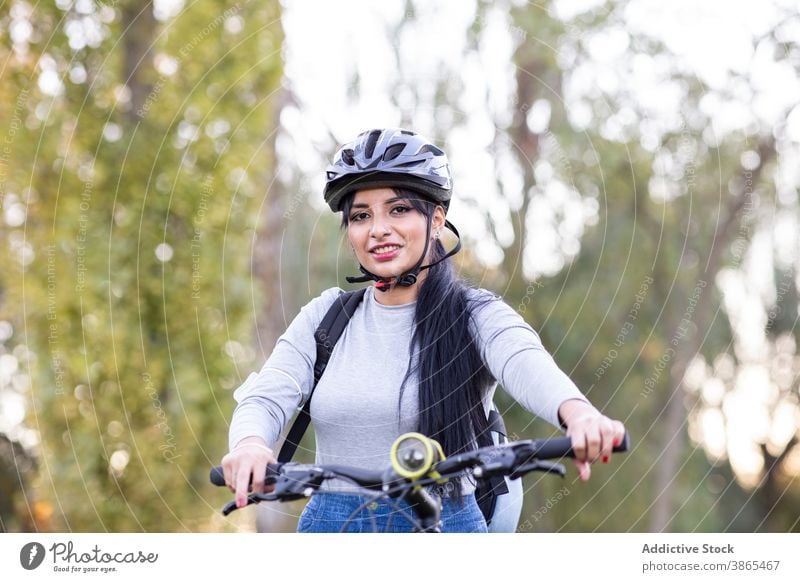 Happy woman riding bike in autumn forest bicycle ride active happy countryside nature cheerful female smile trail path activity bicyclist journey explore young