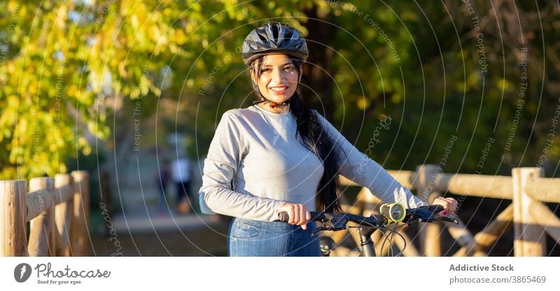 Happy woman riding bike in autumn forest bicycle ride active happy countryside nature cheerful female smile trail path activity bicyclist journey explore young