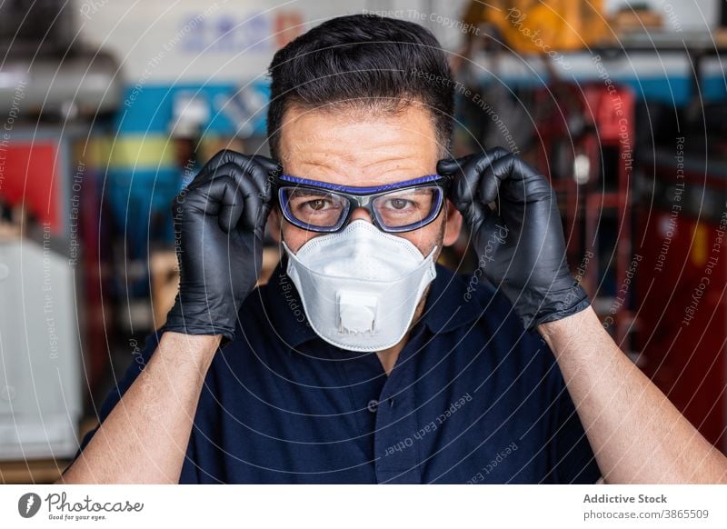 Male technician putting on goggles man mechanic put on garage respirator glove prepare protect worker male latex adult safety mask equipment job professional