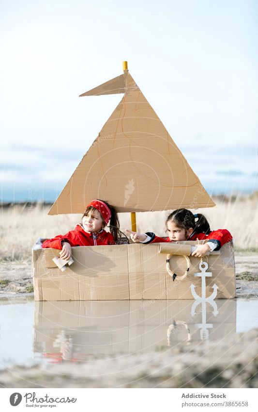 Curious kids playing in carton boat in countryside cardboard child together having fun spyglass inspiration game creative imagination girl handmade cheerful