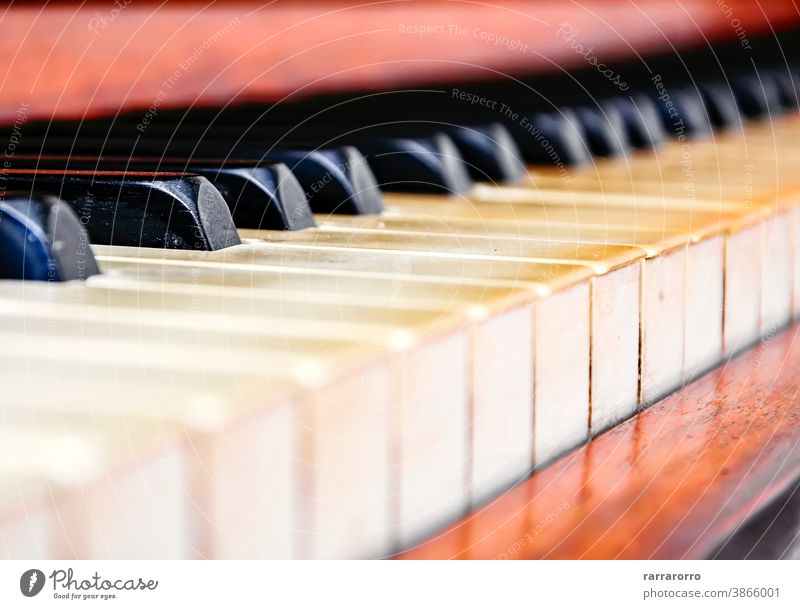 Close up of the keys of an old worn piano. keyboard instrument musical detail black key wood ivory antique selective focus art vintage white classical sound