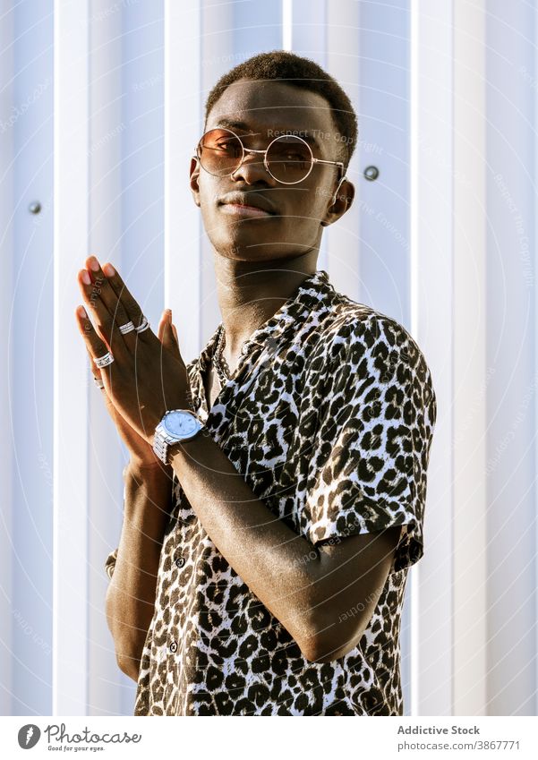 Ethnic man in stylish outfit on street style leopard sunglasses city trendy cheerful thumb up gesture young male black shaka ethnic african american content