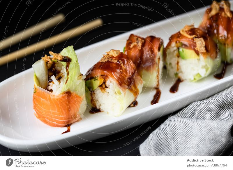 Tasty rolls with turnip and sauce asian food sushi delicious teriyaki serve chopstick oriental fresh palatable tradition portion restaurant culinary tasty