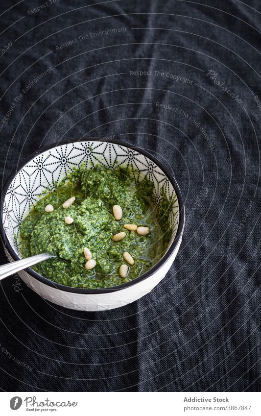 Bowl with pesto sauce on black background bowl green fresh nut aromatic food herb natural pine delicious mediterranean tasty ingredient cuisine tradition meal
