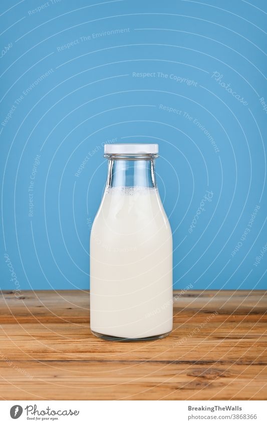 Close up one glass bottle of milk over blue Milk yogurt yoghurt fresh full closeup background table low angle view side front dairy white food ingredient drink