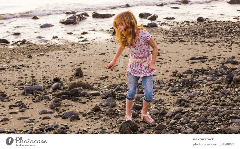 Blond Girl Playing on Rocky Beach child girl female caucasian beach sand standing playing sea shore rock rocky 1 person 5 years old blond fun full length