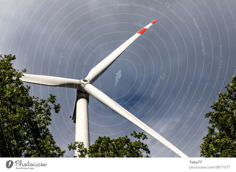 a wind turbine in the forest in the sun wind wheel electricity energy green energy storm clouds modern wind turbine