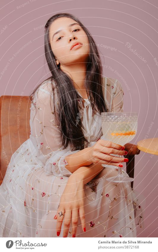 Young woman with glass of cocktail in hand. Studio photo with pink background. alcohol attractive beautiful beauty beverage drink elegant fashion female