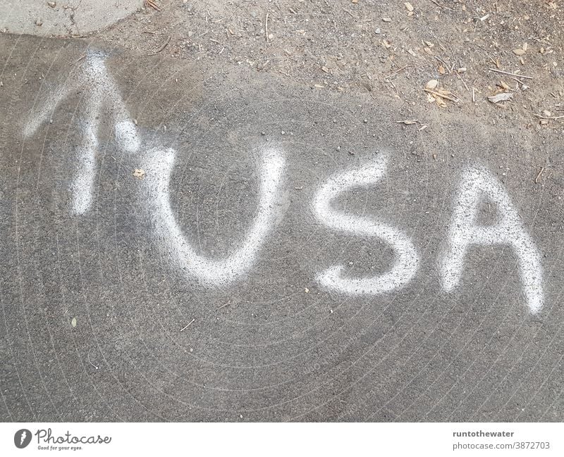 USA letters on the street Arrow Street Clue Direction Trend-setting North United States united states of america Americas American urban travel Concrete