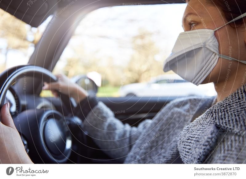 Young woman wearing protective mask driving car caucasian young female steering vehicle horizontal face person adult drive millennial young adult steering wheel