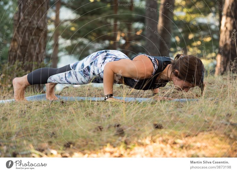 Woman practices yoga alone in the forest Back view Outdoor activity Young attractive Asian woman practicing yoga, exercising exercising working out Women is meditating alone at sunrise.