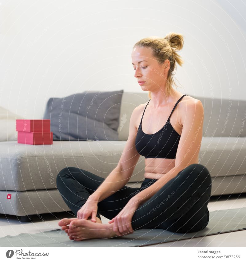 Portrait of gorgeous active sporty young woman practicing yoga in studio.  Beautiful girl practice Sasangasana, rabbit yoga pose. Healthy active  lifestyle, working out indoors in gym - a Royalty Free Stock Photo