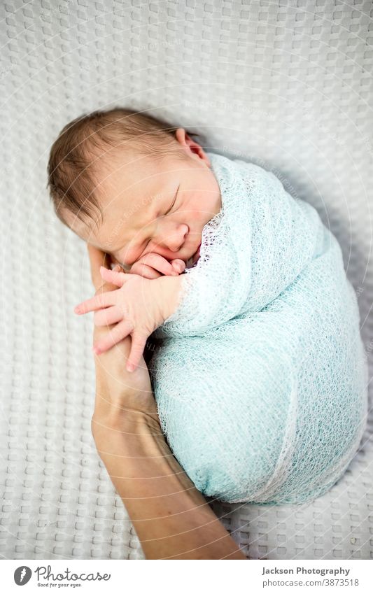 Smiling newborn baby boy wrapped in blue laying on mother's hand smile sleeping baby adorable asleep mommy beautiful beauty blanket care caucasian child