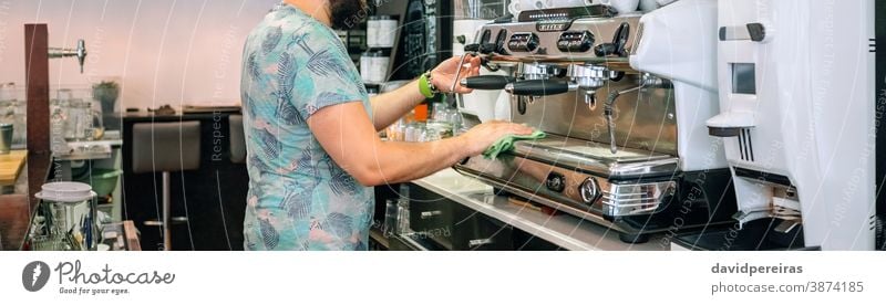 Young waiter cleaning the coffee machine cloth morning coffee shop cafe banner web header panorama panoramic unrecognizable professional service espresso