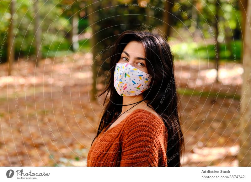 Young woman in protective mask in park coronavirus covid 19 covid19 infection prevent portrait pandemic cloth textile confident young brunette colorful female