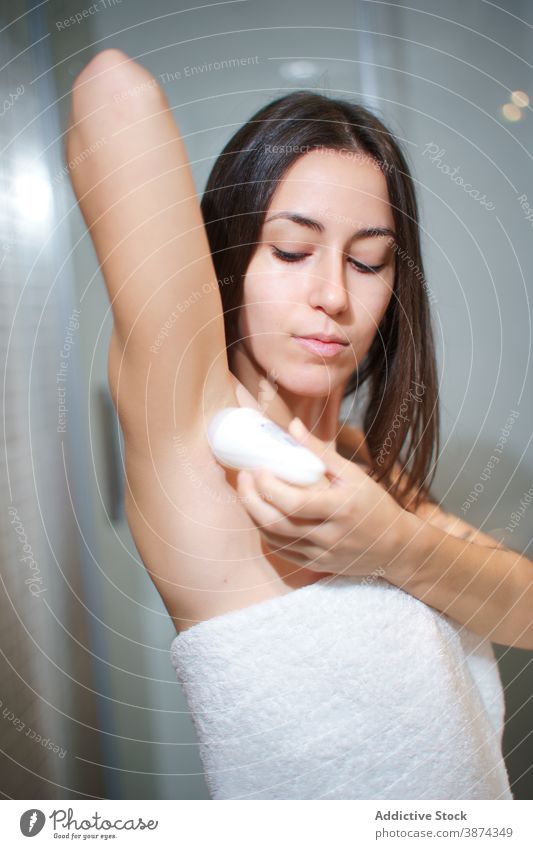 Tender woman applying deodorant on armpit antiperspirant hygiene skin care body care towel bathroom female clean healthy fresh natural daily beauty treat home