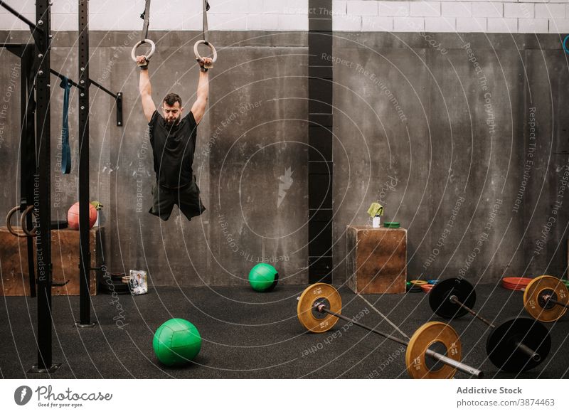 Muscular man exercising on gymnastic rings functional workout strong exercise athlete training male sportswear power fit endurance modern strength wellness