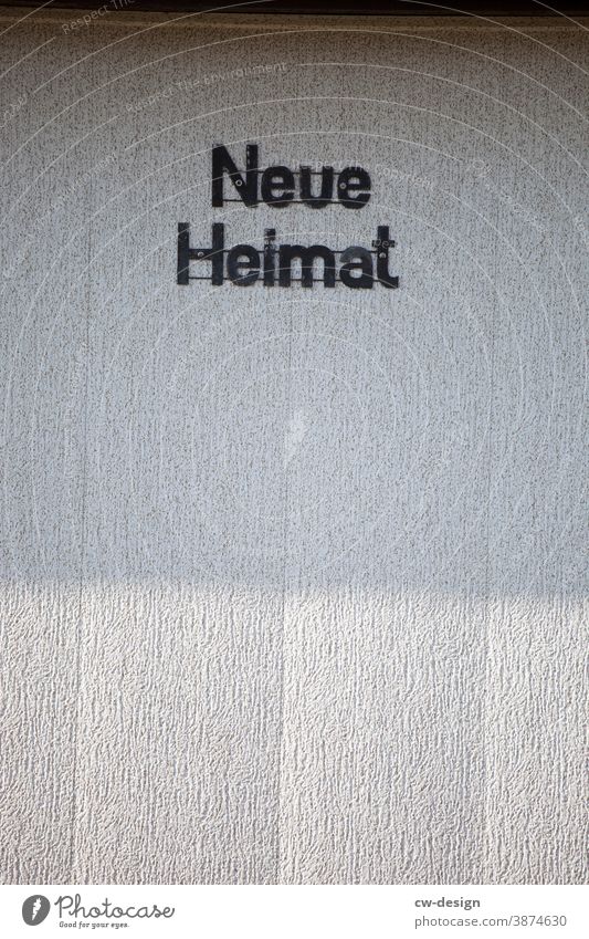 Facade with inscription "Neue Heimat Home country New home House (Residential Structure) Exterior shot Colour photo Wall (barrier) Building Deserted