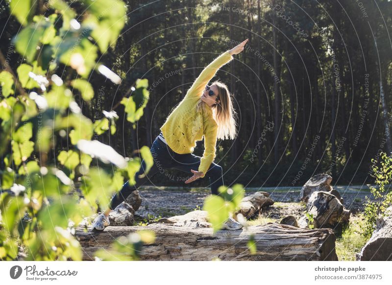 Woman doing yoga on a tree trunk in the forest Yoga Forest Tree trunk Green Environment Nature Exterior shot Colour photo Day Sports Movement leaves Landscape