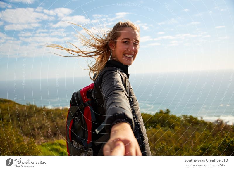 POV Shot Of Young Woman Hiking In Countryside By Sea Encouraging Partner To Follow Her pov point if view follow me couple hiking woman hike young women walk