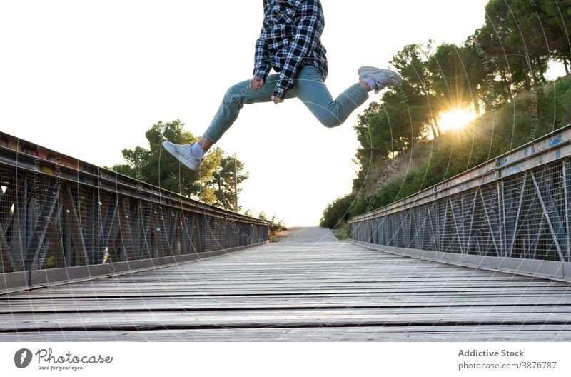 Energetic hipster man jumping over wooden bridge high energy having fun leap active fly male footbridge way footpath freedom enjoy activity carefree optimist