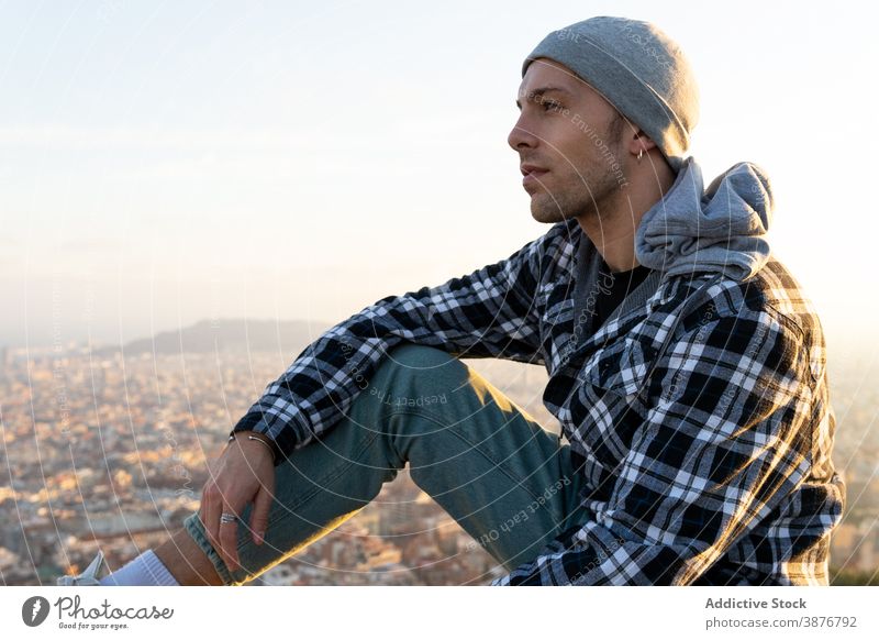 Pensive traveler sitting on hill contemplating views hipster pensive thoughtful man contemporary think male lifestyle guy adventure tourist relax rest calm