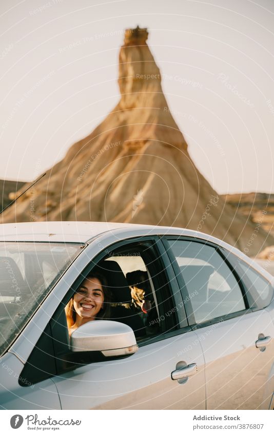Cheerful woman sitting in car in nature bardenas reales traveler badland vacation sunny automobile cheerful sightseeing female road trip spain tourist rest