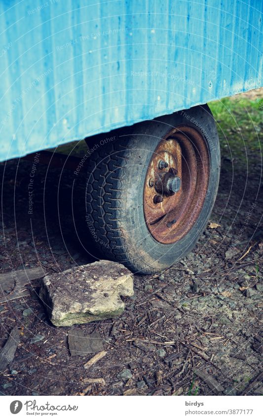 Wheel of an old construction wagon with a stone in front of it as roll away protection. drag shoe Drag shoe Safety Site trailer Tire rusty Block Parking Stone