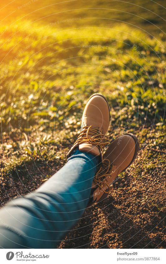 Detail of some feet relaxing boots woman grass copy space relaxation sunset hiking tourism tourist unrecognizable young rest morning dawn sunlight outdoors