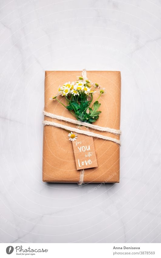 Eco friendly gift wrapped in brown paper wrapping flowers chamomile holiday box present celebration surprise handmade creative mothers day zero waste wedding