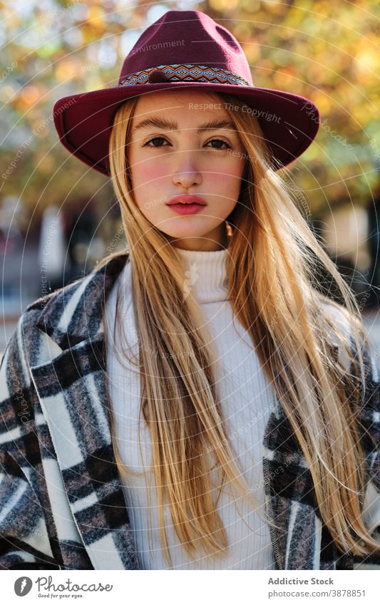 Relaxed woman in trendy outfit and hat in autumn park fashion style checkered relax fall season young female blond millennial teenage enjoy tranquil calm rest
