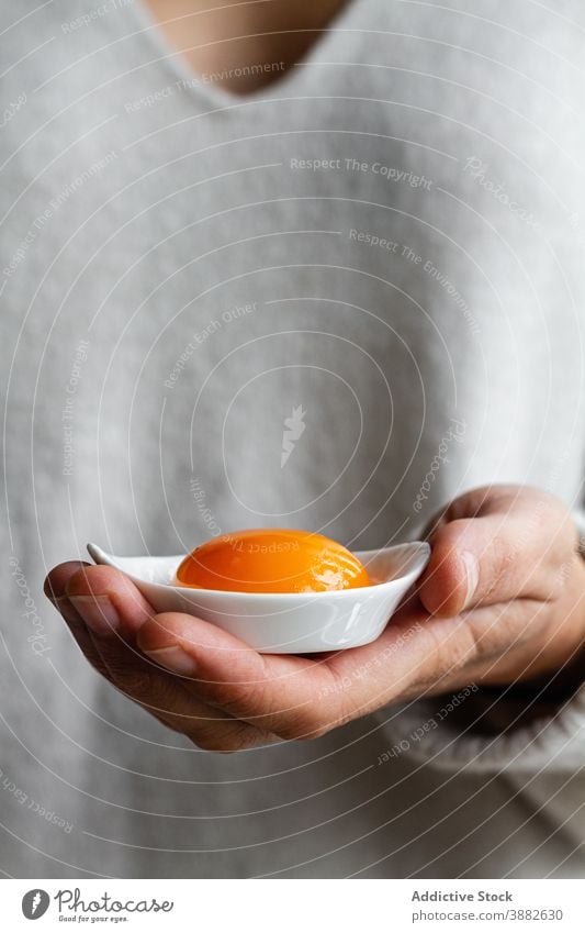 Person holding bowl with egg yolk kitchen raw uncooked yellow food ingredient culinary person show demonstrate meal cuisine recipe gastronomy natural prepare