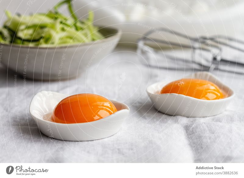 Egg yolks on table with ingredients for recipe egg raw kitchen prepare food breakfast meal cuisine morning natural healthy green cook dish nutrition bowl fresh