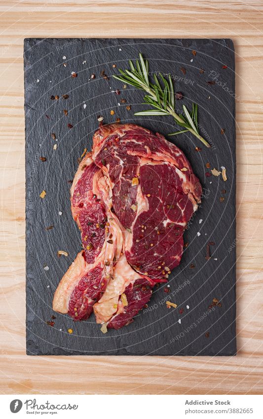 Raw beef steak with rosemary on slate board raw meat rib eye entrecote food uncooked cuisine ingredient culinary gourmet meal protein natural recipe product