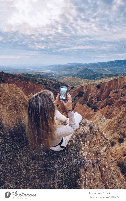Woman photographing rocky formations on smartphone woman mountain take photo traveler nature adventure wild environment erosion landscape mobile female gadget