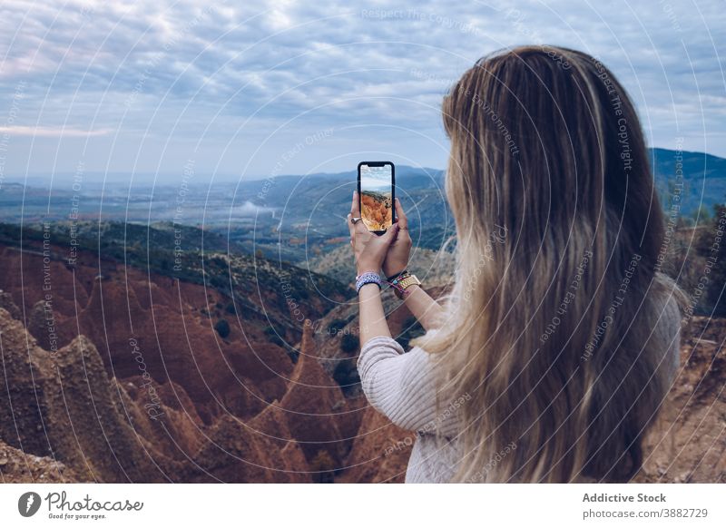 Woman photographing rocky formations on smartphone woman mountain take photo traveler nature adventure wild environment erosion landscape mobile female gadget